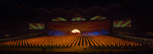 North Korean dancers in front of rising sun over mount Paektu made by children holding up boards during Arirang mass games in may day stadium, Pyongan Province, Pyongyang, North Korea