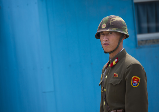 North Korean soldier wearing an helmet standing in front of the United Nations conference rooms on the demarcation line in the Demilitarized Zone, North Hwanghae Province, Panmunjom, North Ko