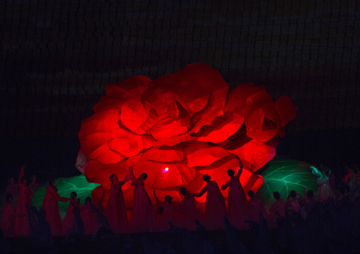 North Korean women dancing in front of a giant Kimilsungia flower during the Arirang mass games in may day stadium, Pyongan Province, Pyongyang, North Korea