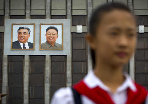 Pioneer girl in Mangyongdae children's palace in front of the portraits of the Dear Leaders, Pyongan Province, Pyongyang, North Korea