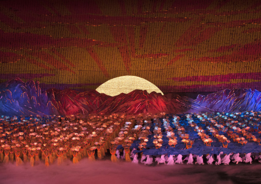 North Korean dancers in front of rising sun over mount Paektu made by children holding up boards during Arirang mass games in may day stadium, Pyongan Province, Pyongyang, North Korea