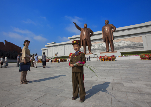 North Korean boy in army uniform paying respect to the two statues of the Dear Leaders in Grand monument of Mansu hill, Pyongan Province, Pyongyang, North Korea