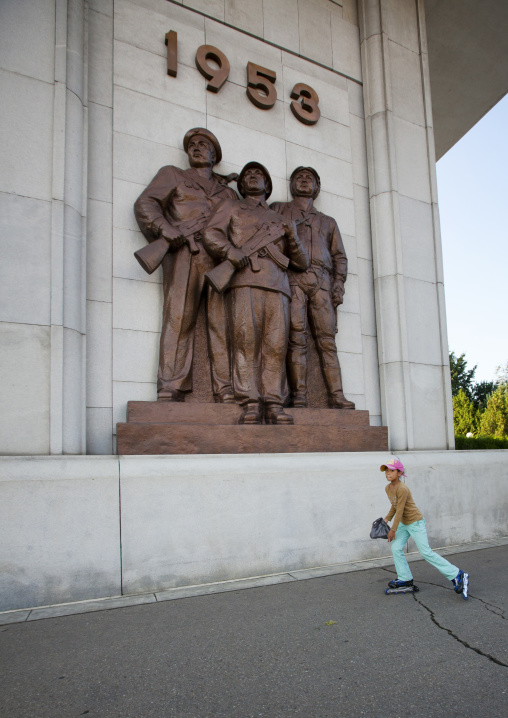 North Korean girl roller skating in front of monument to the victorious fatherland liberation war museum, Pyongan Province, Pyongyang, North Korea