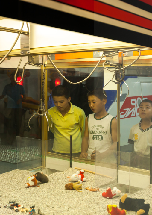 North Korean children playiong with a claw machine in Kaeson youth park, Pyongan Province, Pyongyang, North Korea
