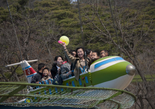 North Korean people having fun on a flying saucer attraction in Taesongsan funfair, Pyongan Province, Pyongyang, North Korea