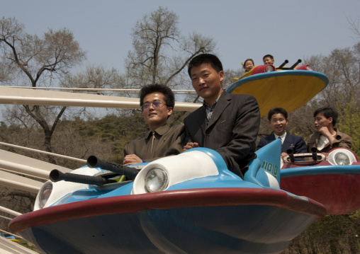 North Korean people having fun on a flying saucer attraction in Taesongsan funfair, Pyongan Province, Pyongyang, North Korea