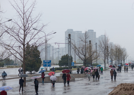 North Korean people walking in the street under the rain, Pyongan Province, Pyongyang, North Korea