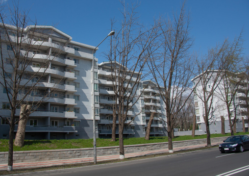 Car passing by new modern city buildings, Pyongan Province, Pyongyang, North Korea