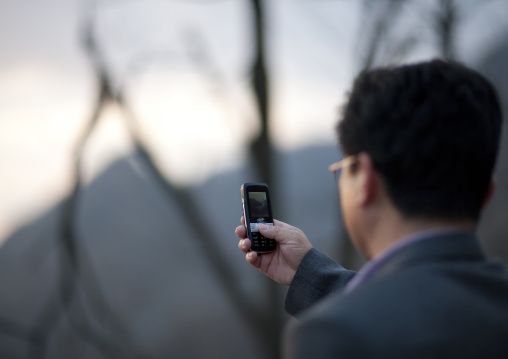 North Korean man taking pictures with his mobile phone, Kangwon Province, Wonsan, North Korea