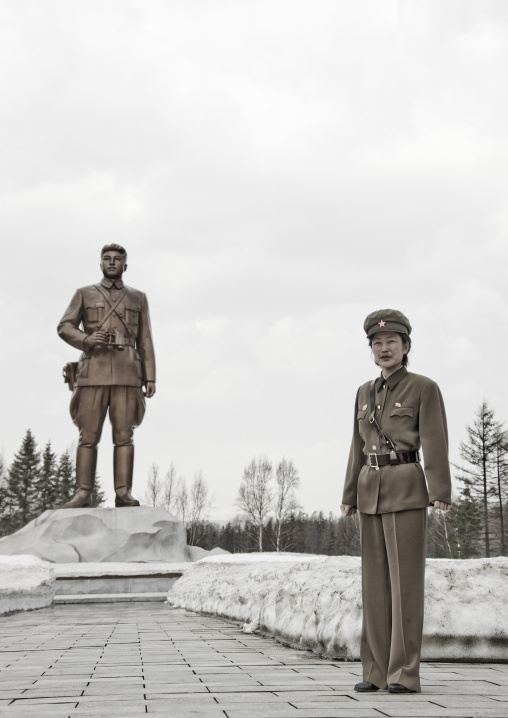 Portrait of a North Korean guide in mount Paektu in front of a Kim il Sung statue, Ryanggang Province, Samjiyon, North Korea