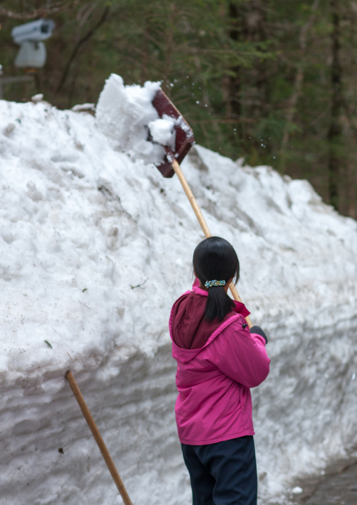 North Korean woman removing snow in the former secret camp of the Korean resistance against japanese, Ryanggang Province, Samjiyon, North Korea