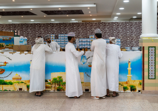 Omani men buying halwa in a shop, Ad Dakhiliyah Region, Nizwa, Oman