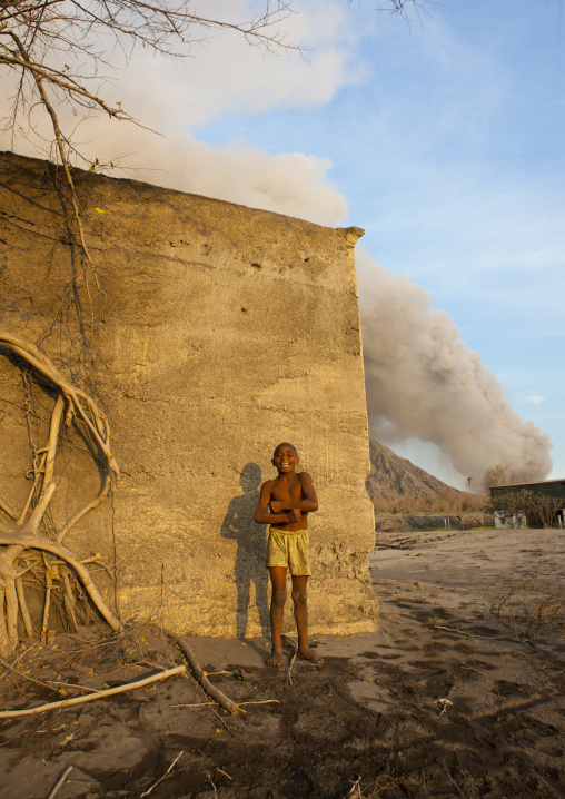 Boy under a volcanic eruption in tavurvur volcano, East New Britain Province, Rabaul, Papua New Guinea