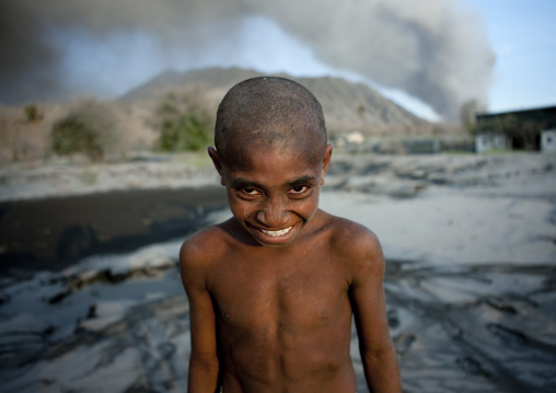 Boy under a volcanic eruption in tavurvur volcano, East New Britain Province, Rabaul, Papua New Guinea