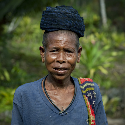 Old mourning woman with shaved head and betel nut in the mouth, Milne Bay Province, Trobriand Island, Papua New Guinea