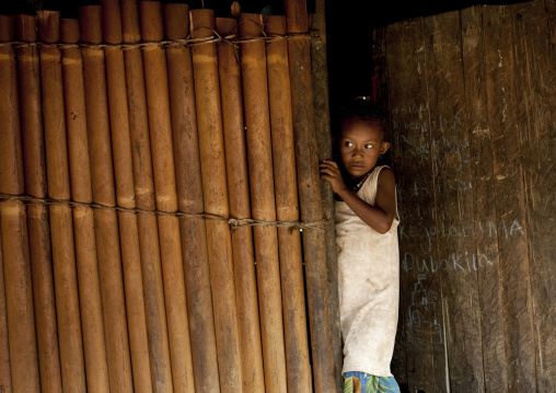 Little girl coming out of her bamboo house, Milne Bay Province, Trobriand Island, Papua New Guinea