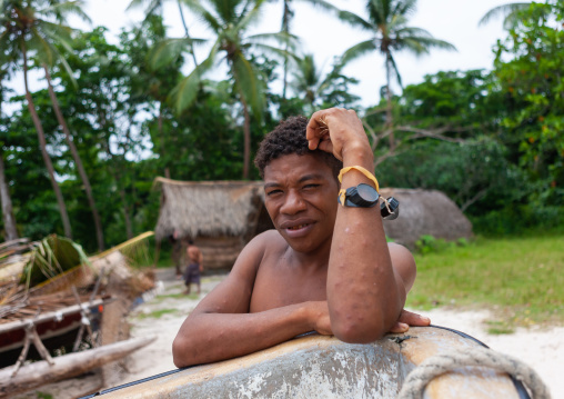 Man in front of kula canoe decorated with shells, Milne Bay Province, Trobriand Island, Papua New Guinea