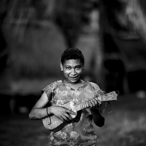 Girl playing guitar, Milne Bay Province, Trobriand Island, Papua New Guinea