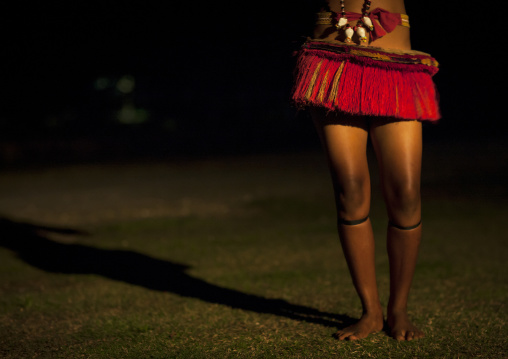 Woman wearing a traditional red skirt made with pandanus and banana leaves, Milne Bay Province, Trobriand Island, Papua New Guinea