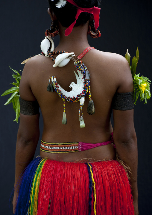 Woman wearing a traditional red skirt made with pandanus and banana leaves, Milne Bay Province, Trobriand Island, Papua New Guinea