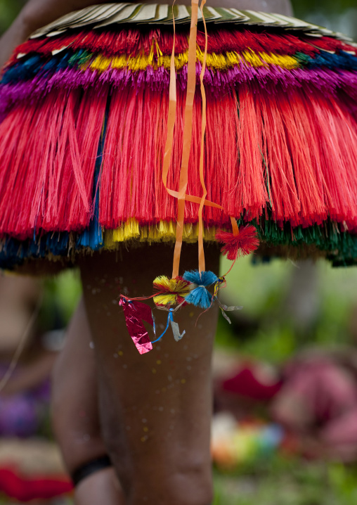 Woman wearing a traditional red skirt made with pandanus and banana leaves, Milne Bay Province, Trobriand Island, Papua New Guinea
