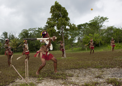 Girls in traditional clothing playing cricket, Milne Bay Province, Trobriand Island, Papua New Guinea