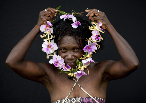 Woman putting a floral necklace around her neck, Autonomous Region of Bougainville, Bougainville, Papua New Guinea