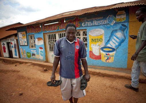 Rwandan man in front of a shop mural, Kigali Province, Kigali, Rwanda