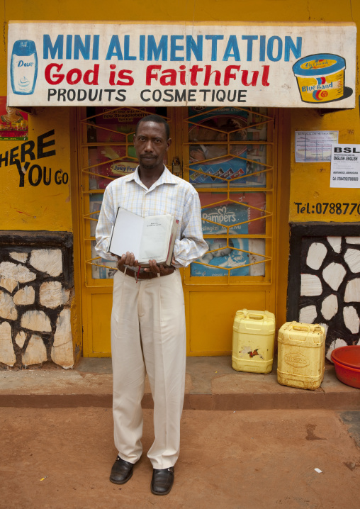 Rwandan man in front of a food shop mural, Kigali Province, Kigali, Rwanda