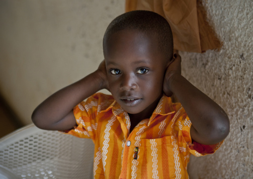 Rwandan child suffering from noise during a sunday mass in a church, Kigali Province, Kigali, Rwanda