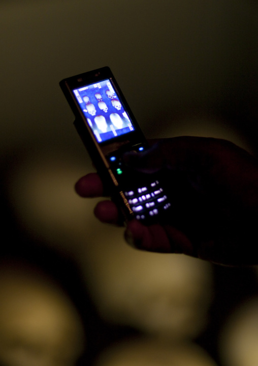 Visitor taking pictures with a mobile phone inside gisozi genocide memorial site, Kigali Province, Kigali, Rwanda