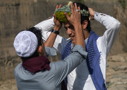 Portrait of a flower man adjusting a floral crown on the head, Jizan province, Addayer, Saudi Arabia