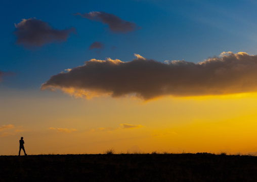 Man silhouette in front of a cloudy sunset, Asir province, Dahran Aljanub, Saudi Arabia