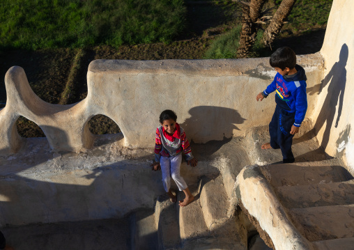 Saudi children playing in a traditional old multi-storey mud house, Najran Province, Najran, Saudi Arabia