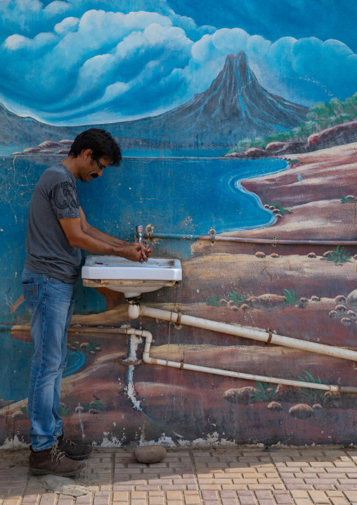 Saudi man washing his hands in a basin, Red Sea, Farasan, Saudi Arabia