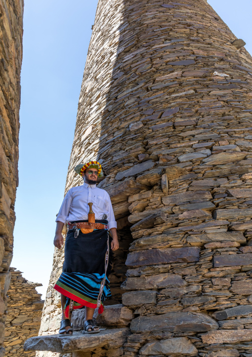 Portrait of a flower man wearing a floral crown on the head near a stone watchtower, Jizan Province, Addayer, Saudi Arabia