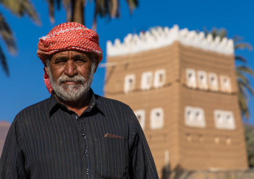 Saudi farmer standing in front of a traditional old mud house, Najran Province, Najran, Saudi Arabia