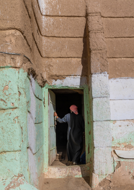 Saudi man entering in a traditional mud house, Najran Province, Najran, Saudi Arabia
