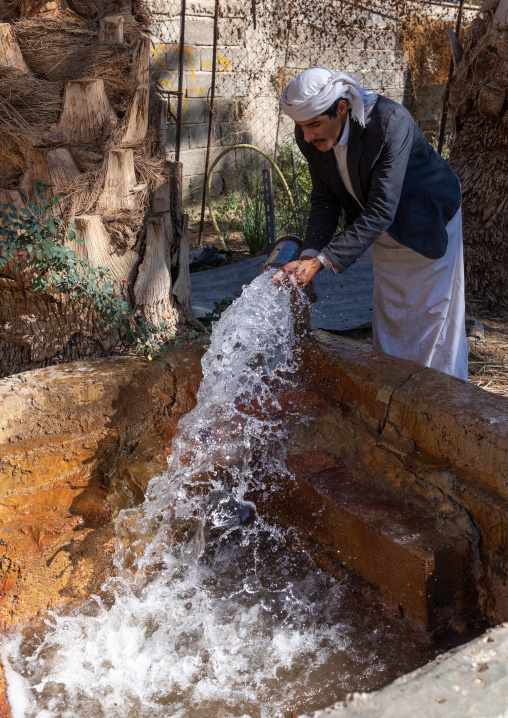 Thirsty saudi man drinking water in a farm well, Najran Province, Najran, Saudi Arabia