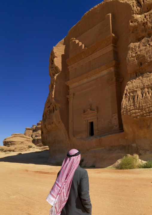 Saudi tourist in front of a Nabataean tomb in al-Hijr archaeological site in Madain Saleh, Al Madinah Province, Alula, Saudi Arabia
