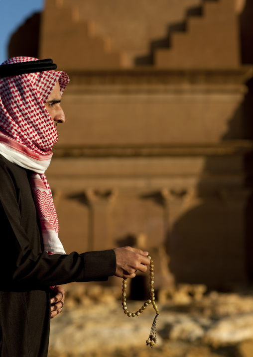 Saudi man in front of a Nabataean tomb in al-Hijr archaeological site in Madain Saleh, Al Madinah Province, Alula, Saudi Arabia