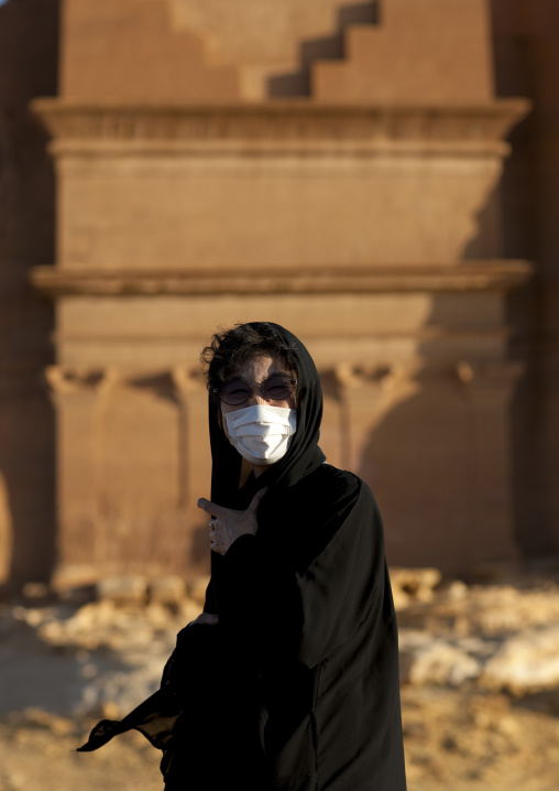 Tourist in front of a Nabataean tomb in al-Hijr archaeological site in Madain Saleh, Al Madinah Province, Alula, Saudi Arabia