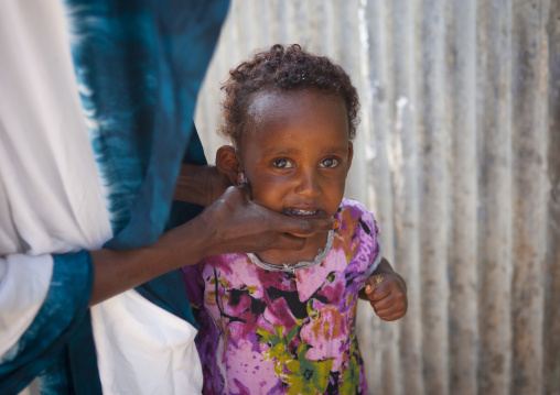 Young Girl Wearing A Pink Flowery Dress Getting Washed By Her Mother, Baligubadle, Somaliland