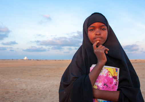 Portrait of a somal girl in black veil with a school book, Awdal region, Zeila, Somaliland
