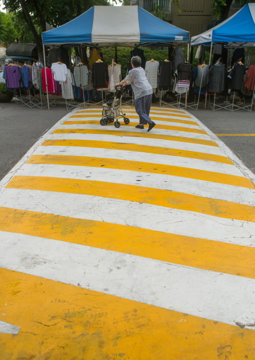 Old woman crossing the road in yangcheong yangcheong where many north korean defectors live, National capital area, Seoul, South korea