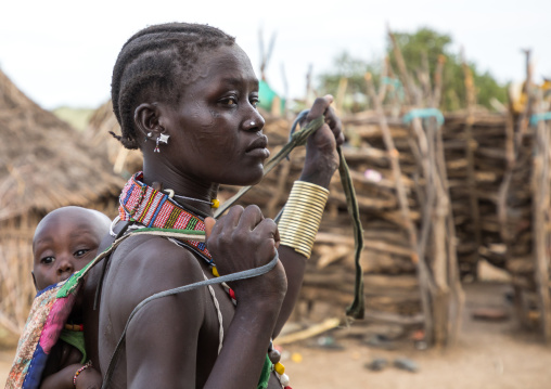 Toposa tribe woman carrying her baby in a sling, Namorunyang State, Kapoeta, South Sudan