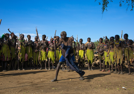 Toposa tribe man dancing in front of women during a ceremony, Namorunyang State, Kapoeta, South Sudan