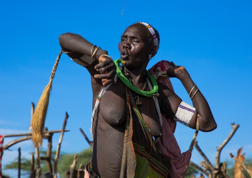 Toposa tribe woman in traditional clothing dancing during a ceremony, Namorunyang State, Kapoeta, South Sudan