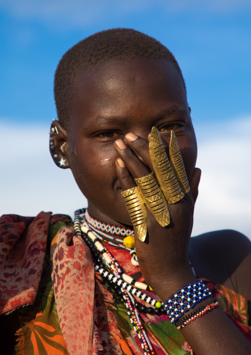 Portrait of a shy Toposa tribe woman with big rings on the hand, Namorunyang State, Kapoeta, South Sudan