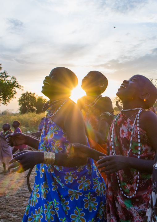 Toposa tribe women in traditional clothing looking at the sky, Namorunyang State, Kapoeta, South Sudan